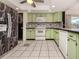 Kitchen features light green cabinets and a patterned backsplash at 143 Rotonda Cir, Rotonda West, FL 33947