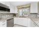 Bright white kitchen with stainless steel appliances and tile backsplash at 160 Salem Nw Ave, Port Charlotte, FL 33952