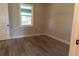 Simple bedroom with wood-look floors and window at 16305 Branco Dr, Punta Gorda, FL 33955