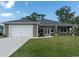 One-story house with gray siding, white garage door, and a landscaped lawn at 16305 Branco Dr, Punta Gorda, FL 33955