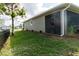 Side view of the house showing screened patio and well-maintained lawn at 16305 Branco Dr, Punta Gorda, FL 33955