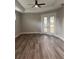 Bright living room with wood-look floors, tray ceiling, and a fan overlooking the yard at 16305 Branco Dr, Punta Gorda, FL 33955