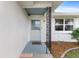 Inviting house entrance with a light gray door, and a decorative metal railing at 18170 Avonsdale Cir, Port Charlotte, FL 33948