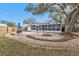 Spacious backyard with screened patio, fire pit, and mature trees at 21190 Midway Blvd, Port Charlotte, FL 33952