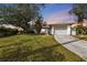 White single-story house with attached garage, viewed at dusk at 21190 Midway Blvd, Port Charlotte, FL 33952