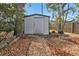 White storage shed in the backyard next to a tree at 21190 Midway Blvd, Port Charlotte, FL 33952