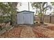 White storage shed nestled in a mulched garden area at 21190 Midway Blvd, Port Charlotte, FL 33952