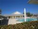 Community pool and clubhouse with surrounding patio at 2180 Heron Lake Dr # K-208, Punta Gorda, FL 33983