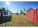 Large backyard with a red fence and grassy area at 230 Waterway Ne Cir, Port Charlotte, FL 33952