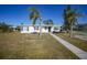 White single story home with palm trees and landscaped lawn at 230 Waterway Ne Cir, Port Charlotte, FL 33952