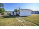 Side view of a white house with grassy yard at 230 Waterway Ne Cir, Port Charlotte, FL 33952