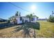 White house exterior with a palm tree and grassy yard at 230 Waterway Ne Cir, Port Charlotte, FL 33952