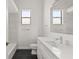 Modern bathroom with white vanity, black floor tile, and patterned wall at 2408 Silver Palm Rd, North Port, FL 34288