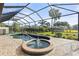 Inviting pool and spa area with screened enclosure and lush landscaping at 2408 Silver Palm Rd, North Port, FL 34288