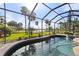 Relaxing pool and spa with screened enclosure overlooking a lush landscape at 2408 Silver Palm Rd, North Port, FL 34288