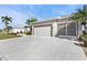 Two-car garage with driveway and landscaping at 24424 Buckingham Way, Punta Gorda, FL 33980