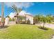 Bright, sunny exterior view of a single story home with palm trees and a large lawn at 25188 Marion Ave # 34, Punta Gorda, FL 33950