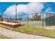 Community tennis court with seating area and surrounding fence at 25188 Marion Ave # 34, Punta Gorda, FL 33950