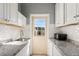 Laundry room with white cabinets, granite countertop and microwave at 2544 Warne St, Port Charlotte, FL 33952