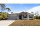 Single-story house with gray siding, a two-car garage, and a landscaped lawn at 2784 Dode Ave, North Port, FL 34288