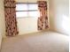 Spacious bedroom with neutral carpeting and floral curtains at 2812 Cabaret St, Port Charlotte, FL 33948