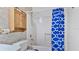 Clean bathroom with shower/tub, blue patterned curtain, and wooden cabinet at 3128 Ponce De Leon Blvd, North Port, FL 34291