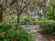 Secluded park bench surrounded by lush landscaping and large shady trees at 3341 Briant St, North Port, FL 34287