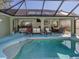 Inviting screened pool area with patio furniture and a hot tub at 3341 Briant St, North Port, FL 34287