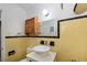 Simple bathroom with yellow tile and a pedestal sink at 350 Duxbury Ave, Port Charlotte, FL 33952