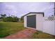 White storage shed with gray door, offering extra storage space at 350 Duxbury Ave, Port Charlotte, FL 33952