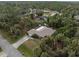 House nestled in a wooded neighborhood with a screened enclosure at 3953 Vehlin St, North Port, FL 34286