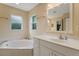 Clean bathroom features a corner soaking tub and white vanity at 3953 Vehlin St, North Port, FL 34286