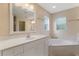 Bright bathroom boasts a soaking tub and vanity with a large mirror at 3953 Vehlin St, North Port, FL 34286