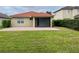 Exterior view of a home showcasing a tile roof, screened lanai, brick patio, and well-manicured backyard at 4269 River Bank Way, Port Charlotte, FL 33980