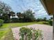 Backyard featuring brick patio, lush lawn, and mature trees at 4269 River Bank Way, Port Charlotte, FL 33980