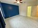 Bright bedroom with modern flooring, a ceiling fan, and a bold accent wall next to closet entry at 4269 River Bank Way, Port Charlotte, FL 33980