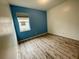 Bedroom with laminate floors, a window, and blue accent wall at 4269 River Bank Way, Port Charlotte, FL 33980