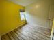 Bedroom with wood-look floors and yellow accent wall at 4269 River Bank Way, Port Charlotte, FL 33980