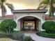 Community clubhouse entrance featuring manicured landscaping and a charming terracotta tile roof at 4269 River Bank Way, Port Charlotte, FL 33980