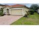 One-story home with tile roof, two-car garage, and landscaped yard at 4269 River Bank Way, Port Charlotte, FL 33980