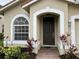 Dark brown front door with arched window and landscaping at 4269 River Bank Way, Port Charlotte, FL 33980