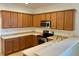 L-shaped kitchen with wood cabinets and stainless steel appliances at 4269 River Bank Way, Port Charlotte, FL 33980