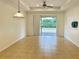 Open-concept living area with neutral tile flooring, a ceiling fan, and sliding glass doors to the outdoors at 4269 River Bank Way, Port Charlotte, FL 33980