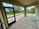 Spacious screened-in patio with brick flooring offering views of the fenced backyard and tropical landscaping at 4269 River Bank Way, Port Charlotte, FL 33980