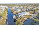 Aerial view of a two-story home with a metal roof, boat dock and lift, and a canal front at 4297 Nettle Rd, Port Charlotte, FL 33953