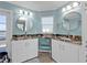 Well-lit bathroom featuring dual sinks with granite countertops and elegant white cabinetry at 4297 Nettle Rd, Port Charlotte, FL 33953