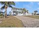 Stunning two-story coastal home with a spacious balcony, lush landscaping, and paved driveway at 4297 Nettle Rd, Port Charlotte, FL 33953