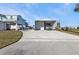 View of large, detached garage and driveway with the house raised on pilings in the background at 4297 Nettle Rd, Port Charlotte, FL 33953