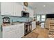 Well-lit kitchen featuring granite countertops, white cabinets, stainless steel appliances, and access to living room at 4297 Nettle Rd, Port Charlotte, FL 33953