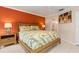 Spacious bedroom with wood bed frame and orange accent wall at 616 Cherrywood Dr, Englewood, FL 34223